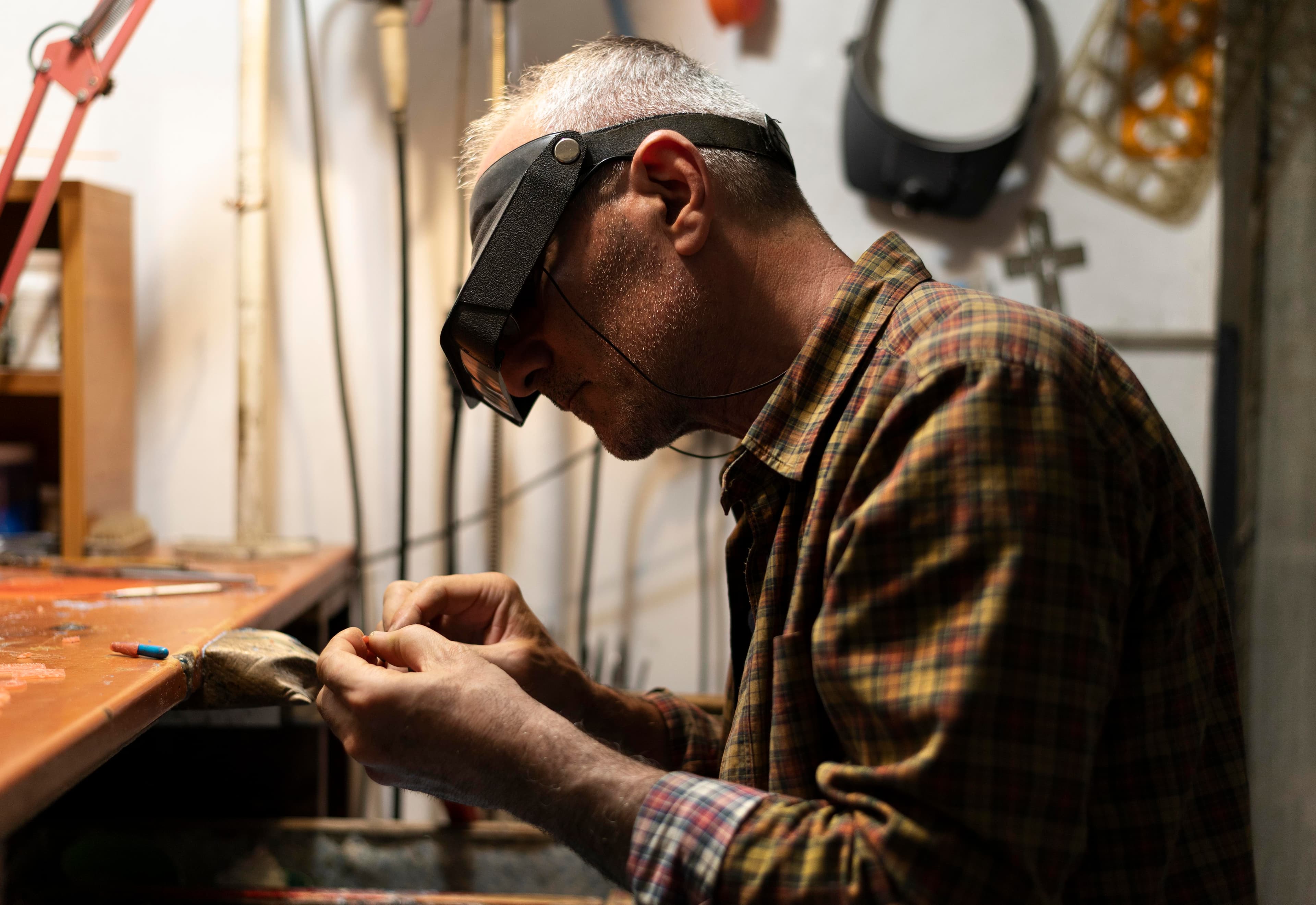 A craftsman working on fine detail at his bench